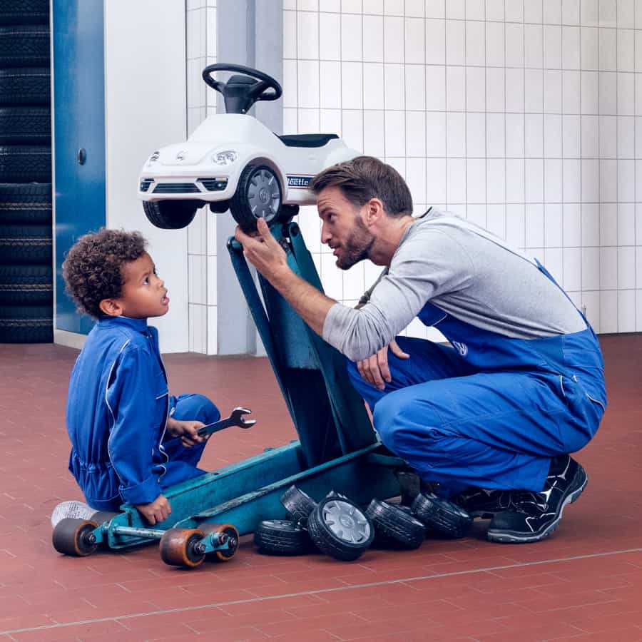 Mechaniker und Sohn reparieren Bobbycar